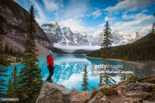 man at moraine lake in autumn, banff, canada - valley of the ten peaks stock-fotos und bilder