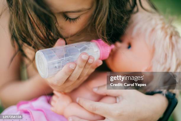 cute girl playing with rubber doll at home - role reversal stock pictures, royalty-free photos & images