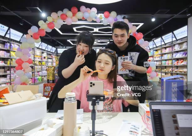 Livestreamers sell food as she live streams video on a smartphone before the Chinese New Year, the Year of the Ox, on January 19, 2021 in Linyi,...