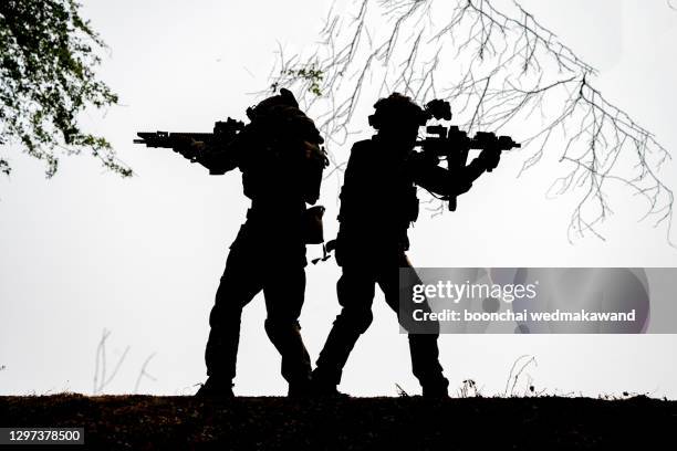 silhouettes of soldiers or officers with weapons in the daytime - infantry imagens e fotografias de stock