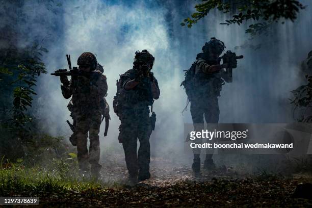 battle of the military in the war. military troops in the smoke - battlefield stockfoto's en -beelden