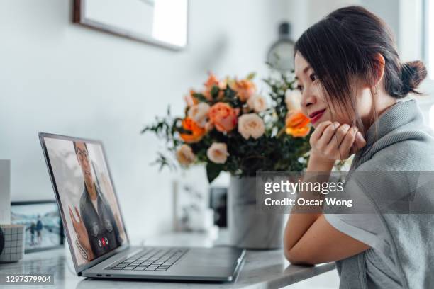 beautiful young woman having a video call with her lover - long distance relationship stock pictures, royalty-free photos & images