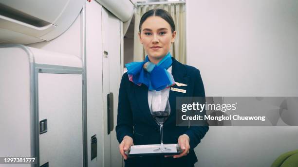 air hostess serving red wine onboard - air stewardess foto e immagini stock