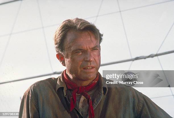 Actor Sam Neill as Dr. Alan Grant, next to an electric fence in a scene from the film 'Jurassic Park', 1993.
