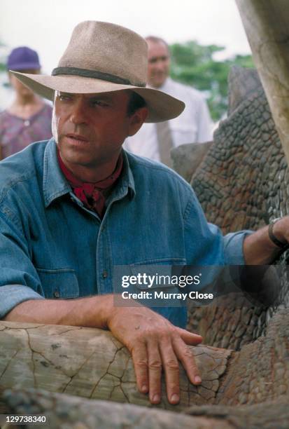 Actor Sam Neill as Dr. Alan Grant, tending to a sick Triceratops in a scene from the film 'Jurassic Park', 1993.