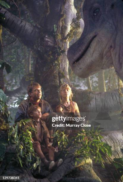 Actor Sam Neill as Dr. Alan Grant, with Ariana Richards and Joseph Mazzello as Lex and Tim, approached by a curious Brachiosaurus in a scene from the...