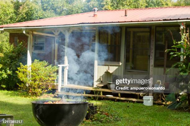 rohes ganzes huhn grillen auf dem grill grillen auf einer hinterhof terrasse. - backyard grilling stock-fotos und bilder