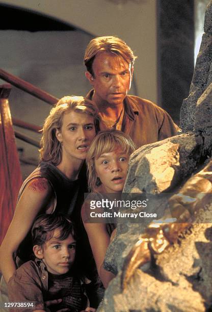 Actor Sam Neill as Dr. Alan Grant and actress Laura Dern as Dr. Ellie Sattler, with Ariana Richards and Joseph Mazzello as Lex and Tim, in a scene...