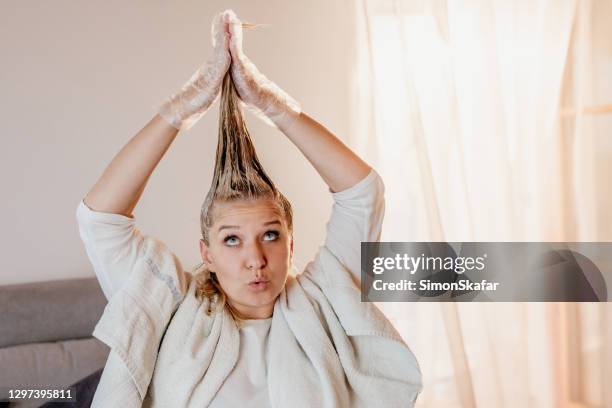 frau färbt ihre haare zu hause - färbemittel stock-fotos und bilder