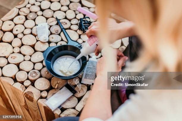 woman pouring hair dye ingredient in bowl - color dye stock pictures, royalty-free photos & images