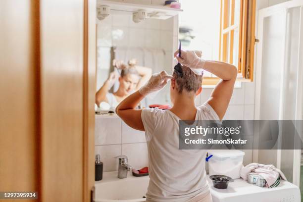 mulher tingindo cabelo em frente ao espelho - bleached hair - fotografias e filmes do acervo