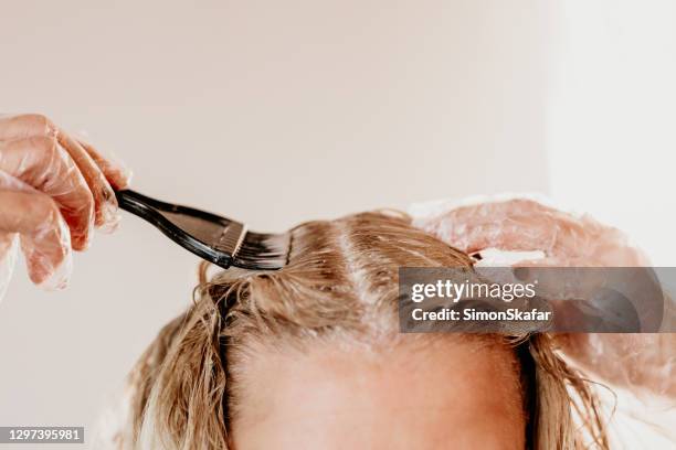 frau färbt haare zu hause - ausmalen stock-fotos und bilder