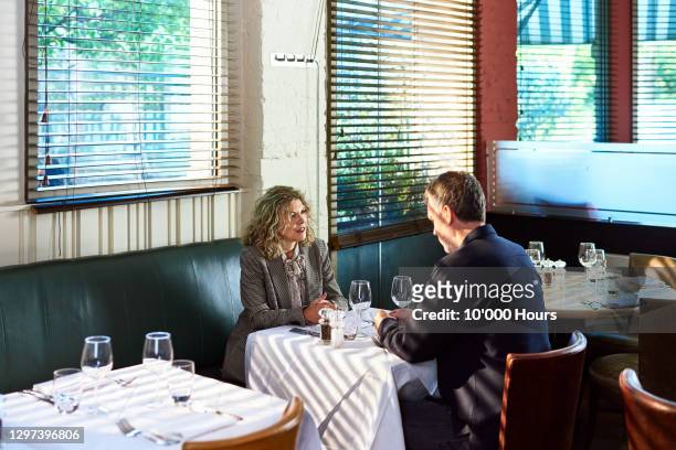 mature couple at table in restaurant - private dining stock pictures, royalty-free photos & images