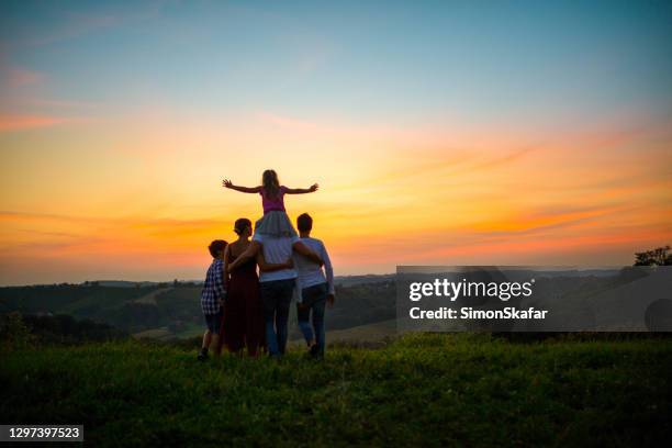 happy family of three during idyllic sunset - family with three children stock pictures, royalty-free photos & images