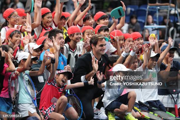 Le joueur de tennis suisse Rodger Federer et le joueur de tennis japonais Kei Nishikori posent avec des enfants lors de "U pniqlo Lifewear day Tokyo"...