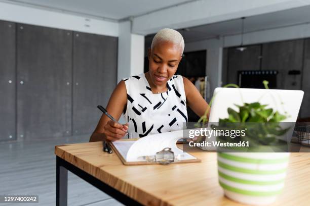 businesswoman working in modern office, using laptop - checkliste stock-fotos und bilder