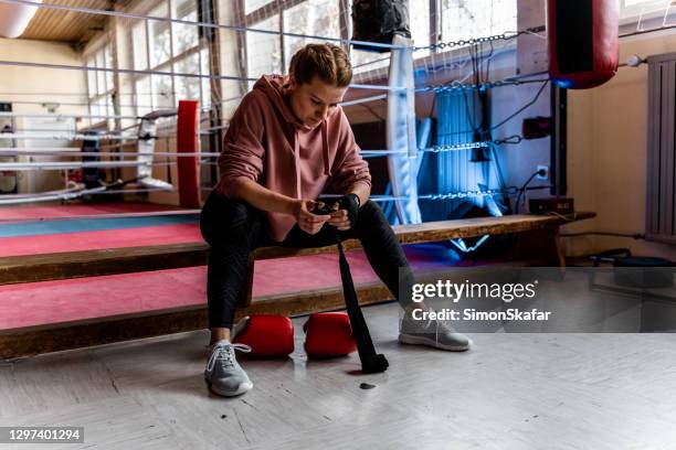 boxerin sitzt auf der bank im fitnessstudio - boxing womens stock-fotos und bilder