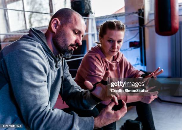 female boxer is learning how to wrapp bandages - kickboxing gloves stock pictures, royalty-free photos & images