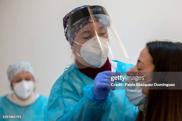 Health care worker performs a rapid COVID-19 disease antigen test on a student at a temporary testing point at Rey Juan Carlos University during the...