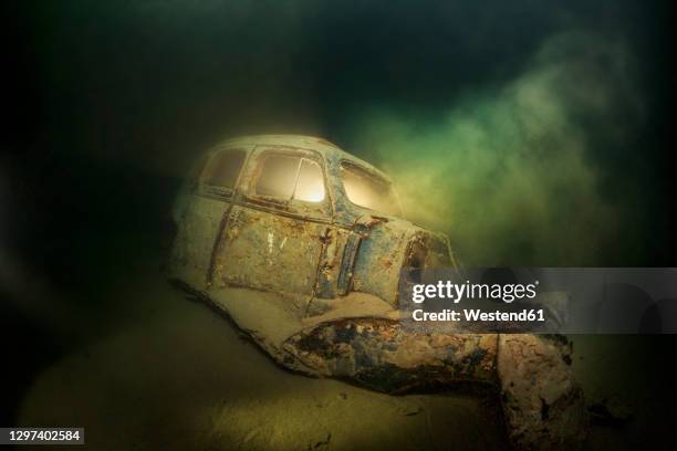 underwater view of rusty car wreck deteriorating at bottom of lake atter - attersee stock pictures, royalty-free photos & images