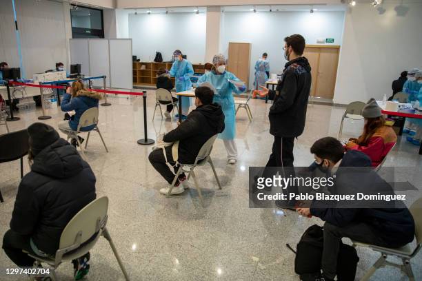 Health care worker gives the result of a rapid COVID-19 disease antigen test to a student at a temporary testing point at Rey Juan Carlos University...