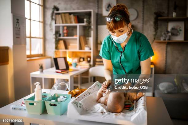 kinderarzt untersucht baby-mädchen mit stethoskop - pediatric nurse stock-fotos und bilder