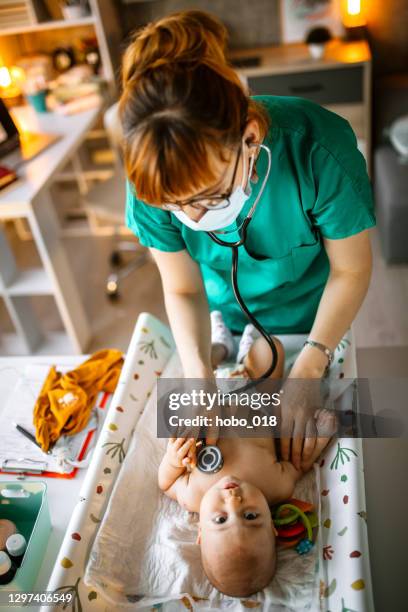 pediatrician examining baby girl using stethoscope - pediatric nurse stock pictures, royalty-free photos & images