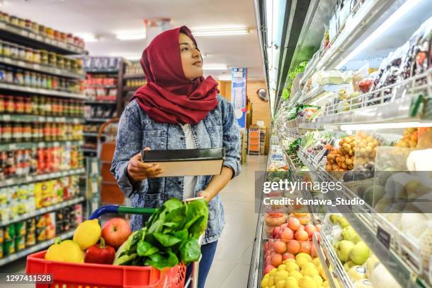 malaysian muslim woman buying a box of fresh dates - asian woman shopping grocery stock pictures, royalty-free photos & images