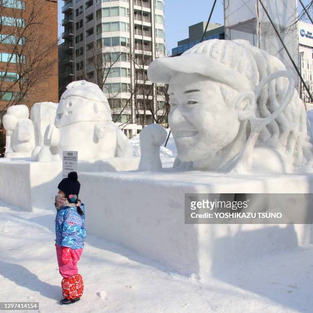 Enfant devant la sculpture de glace représentant le visage de la championne de tennis japonaise Naomi Osaka lors du 70e Festival de la neige le 3...