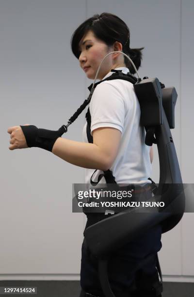 Une employée de la société ATOUN lors d'une démonstration du "Power Assist Suits" pour la hanche permettant de soulever un objet lourd le 17 mai 2019...