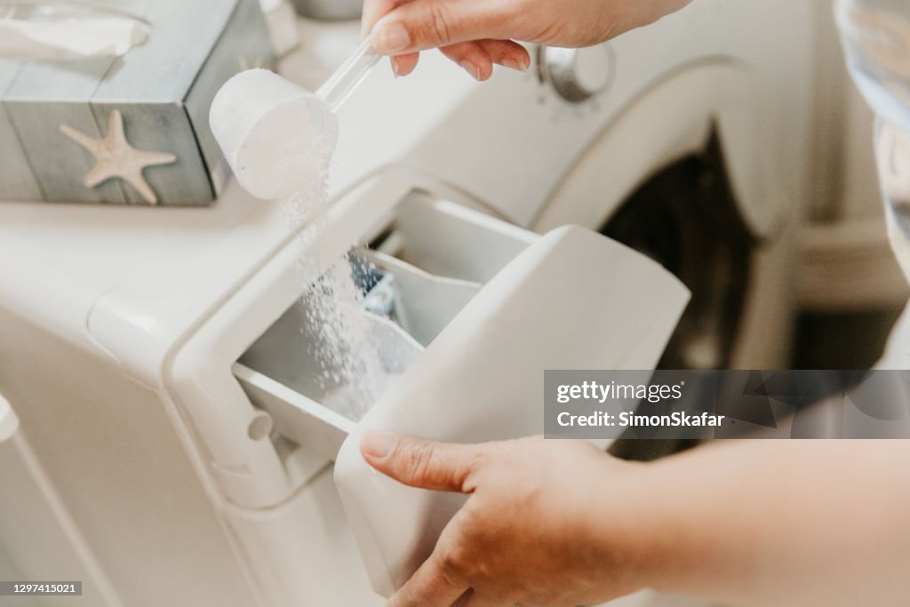 Gießen von Waschpulver in der Waschmaschine