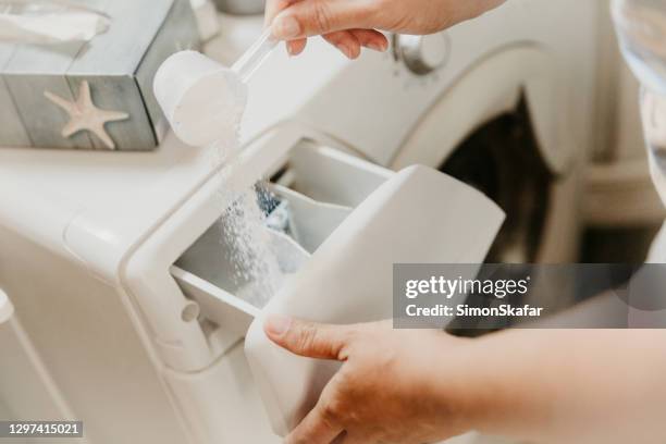 pouring washing powder in washing machine - washing machine stock pictures, royalty-free photos & images