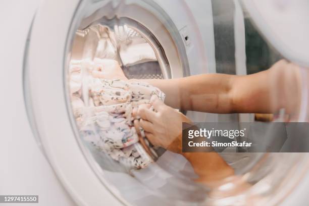 frau nimmt kleidung aus der waschmaschine - remove clothes from stock-fotos und bilder
