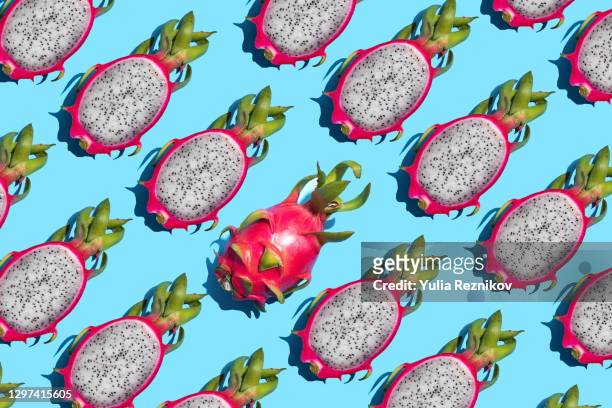 repeated halved pitaya- hylocereus undatus (pitahaya or dragon fruit)on the blue background - röd pitahayafrukt bildbanksfoton och bilder