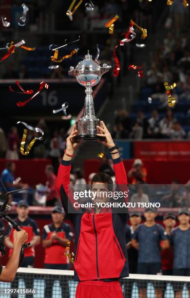 Le joueur de tennis serbe Novak Djokovic, numéro 1 mondial au classement ATP avec son trophée après sa victoire en finale du tournoi "Rakuten Japan...