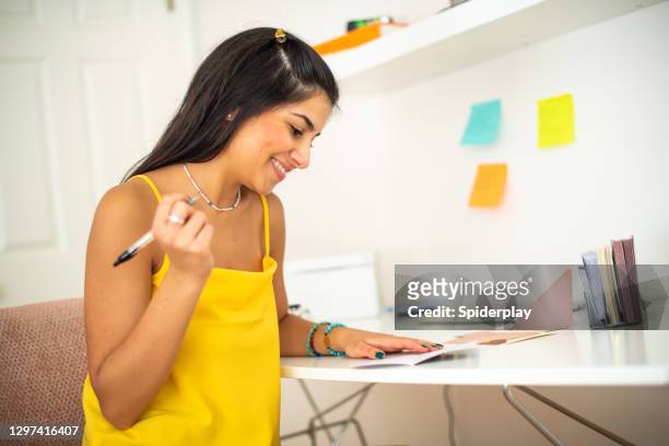 young woman writing a letter at her desk - beautiful armenian women stock pictures, royalty-free photos & images