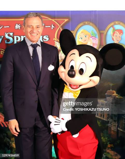 Robert Iger, président de Walt Disney pose pour la photo avec Mickey Mouse lors d'une cérémonie d'inauguration des travaux de la grande zone...