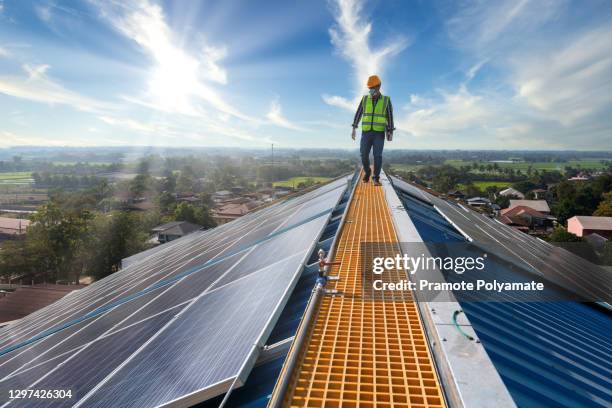 asian technician checks the maintenance of the solar panels, engineering team working on checking and maintenance in solar power plant to innovation of green energy for life on factory roof. - roofing stock-fotos und bilder