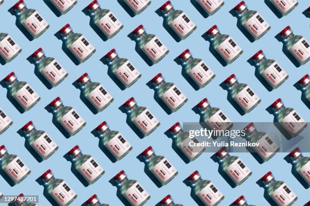 repeated vials with covid-19 vaccine on the blue background - dosis stock-fotos und bilder