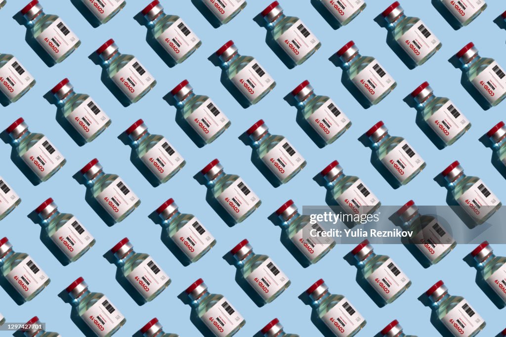 Repeated vials with covid-19 vaccine on the blue background