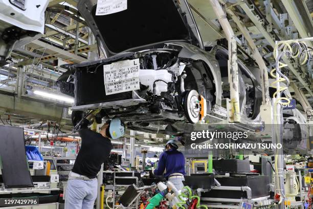 Workers of Japanese automobile giant Toyota Motor assemble auto parts to Lexus GS at the company's Motomachi plant in Toyota city near Nagoya,...
