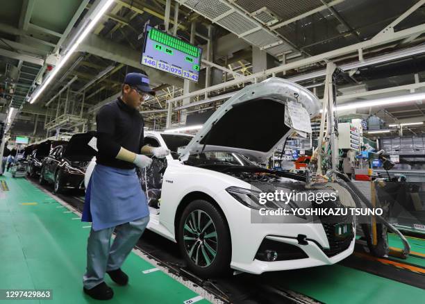 Worker of Japanese automobile giant Toyota Motor assembles auto parts to newly designed Crown at the company's Motomachi plant in Toyota city near...