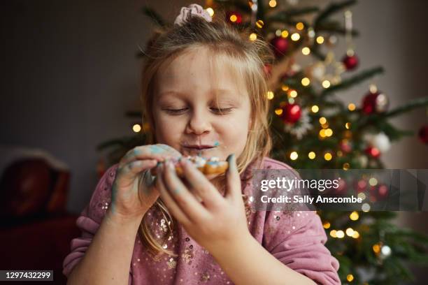 little girl eating a gingerbread - children back stock-fotos und bilder