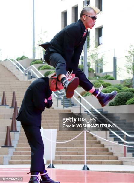 Japanese silent comedy duo "Gamarjobat" members Ketch and Hiro-pon perform at the outside stage of the newly opened Tokyo Midtown Hibiya in Tokyo on...