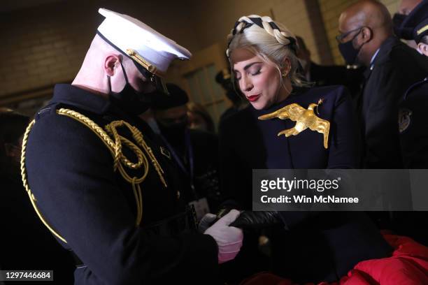 Lady Gaga is escorted by U.S. Marine escort Capt. Evan Campbell to sing the National Anthem at the inauguration of U.S. President-elect Joe Biden on...