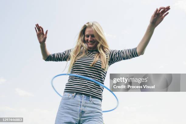 candid portrait of blond female teenager - hoelahoep stockfoto's en -beelden