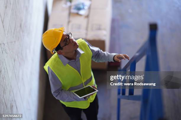 factory manager walking up to stairs - helmet stock pictures, royalty-free photos & images