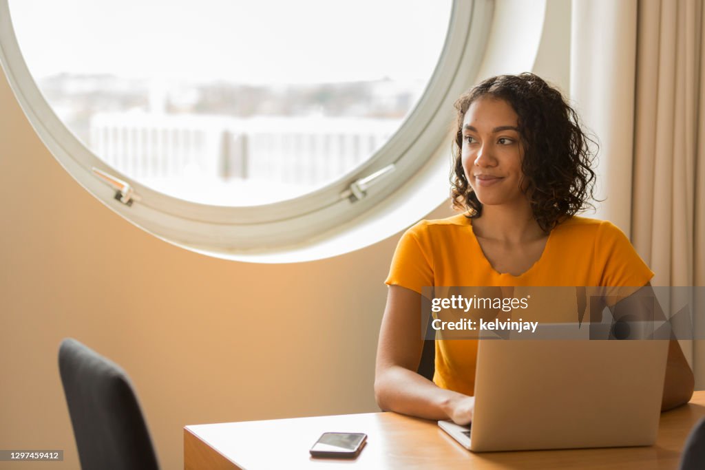 家庭辦公室快樂的年輕女子，使用筆記型電腦
