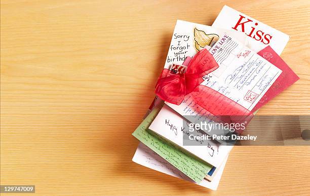 stack of love letters tied with red ribbon - love letter stock-fotos und bilder