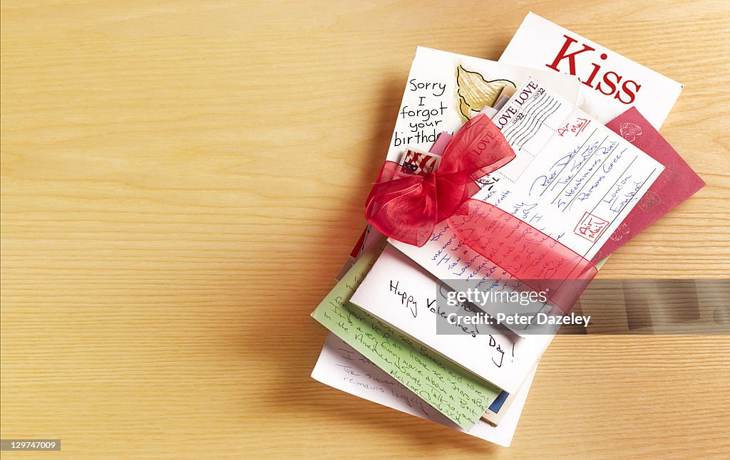 Stack of love letters tied with red ribbon